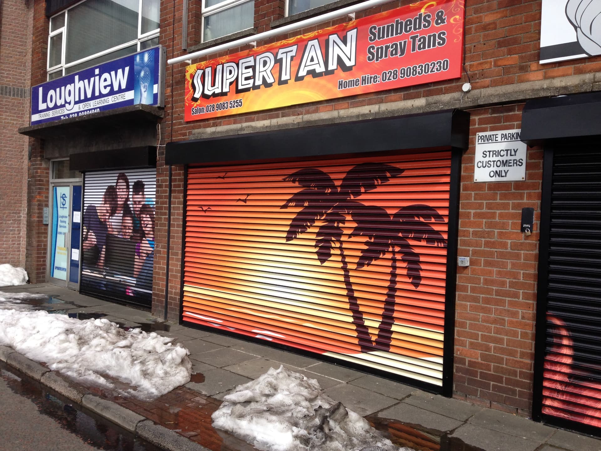 Shopfront graphics wrapping shutter, fascia and window designed, printed and installed by Shutter Media in the UK.