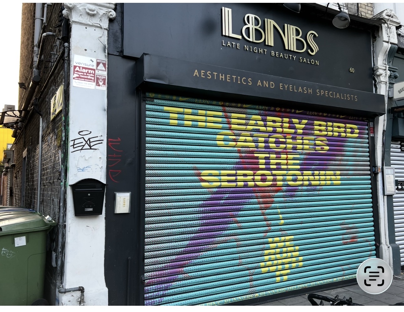 Nike Early Bird Catches the Sero Tonin campaign artwork across a closed beauty salon roller shutter