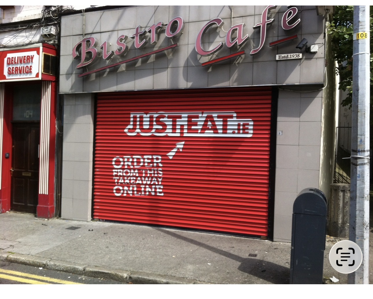 Just Eat order online advertising artwork across a red closed café roller shutter