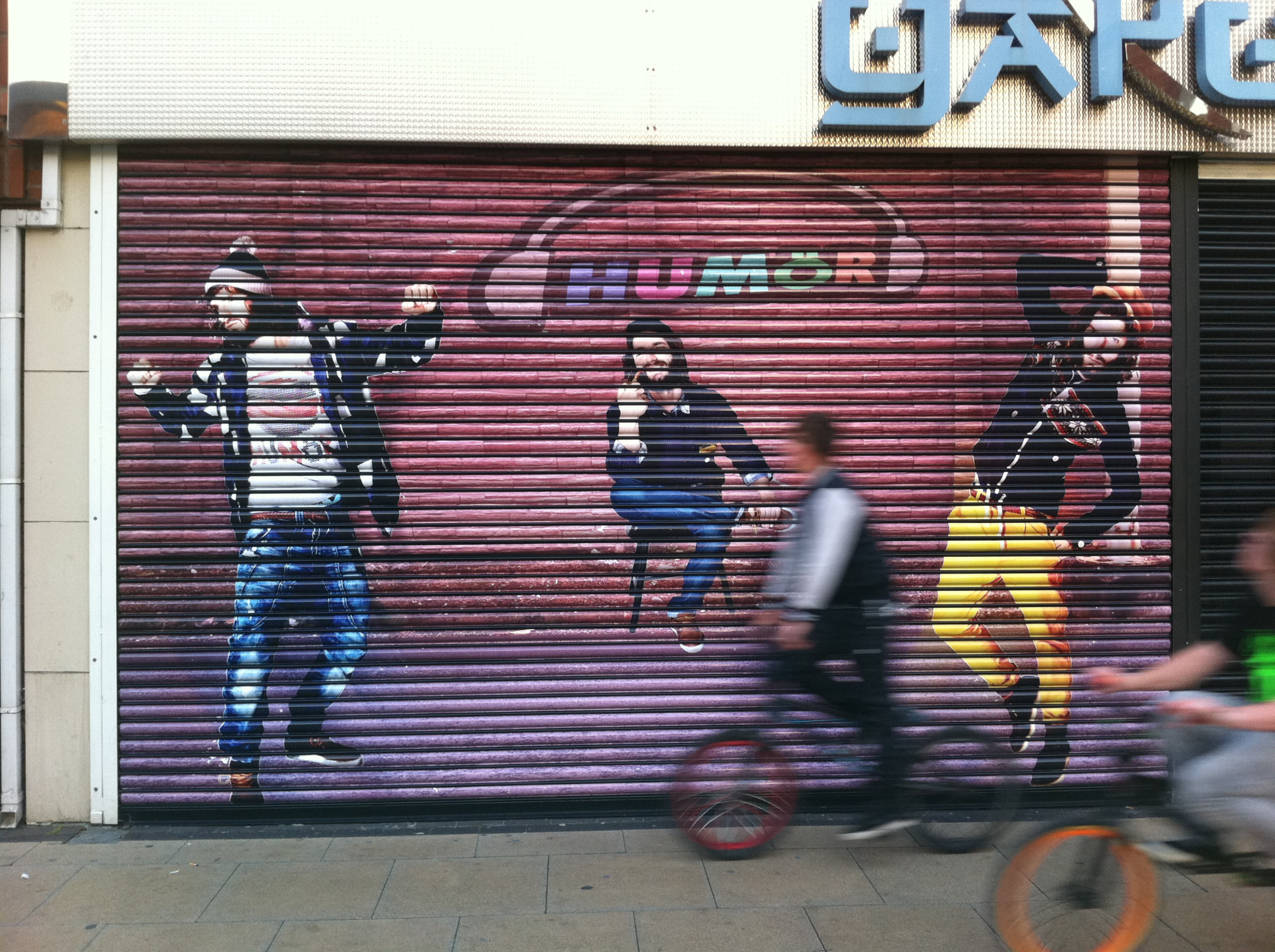 Illustrated shutter artwork covering a closed shopfront designed, printed and installed by Shutter Media in County Durham.