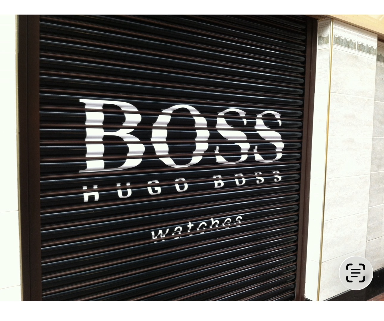 Hugo Boss watches lettering applied across a black closed roller shutter